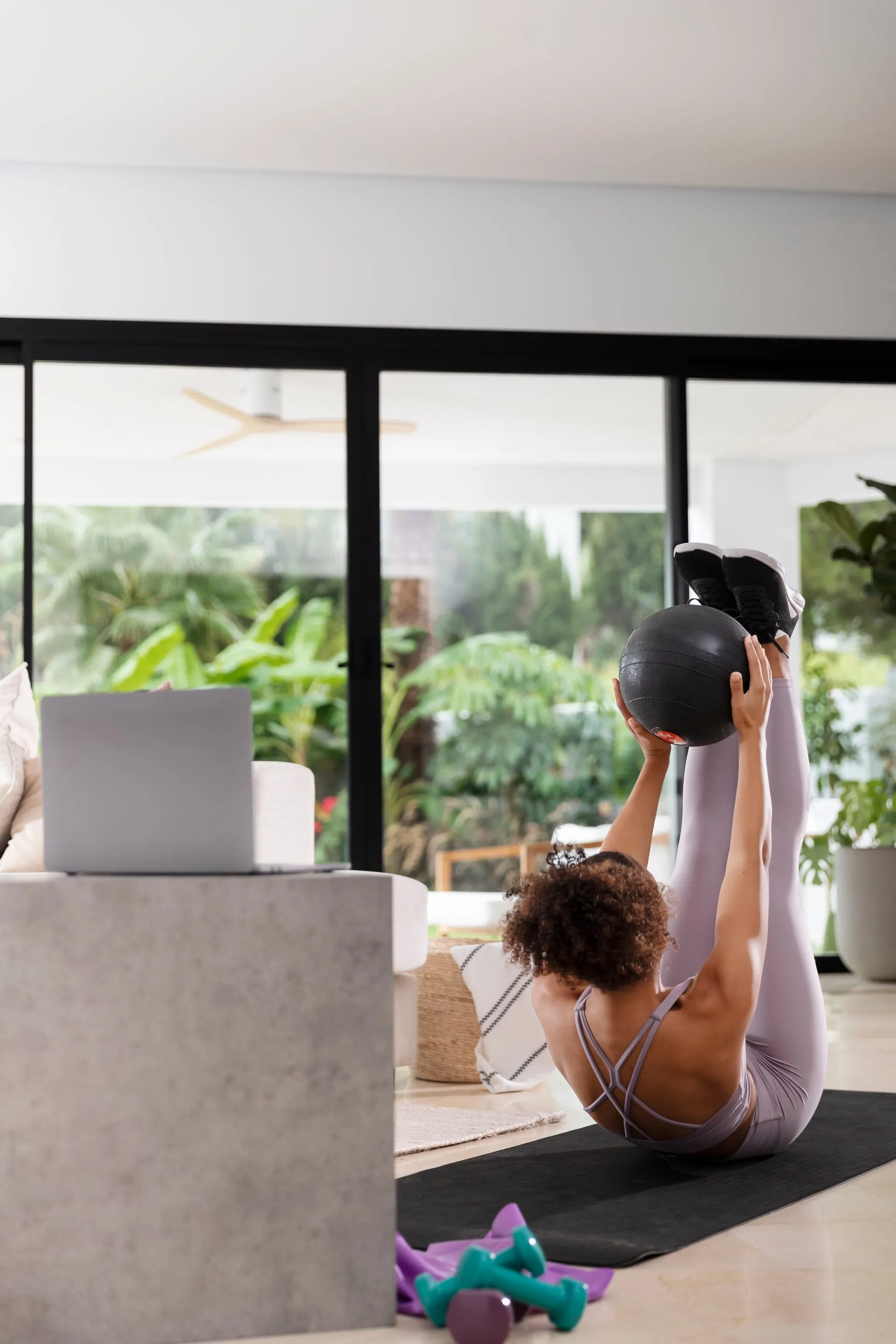 Mujer entrenando con mancuerna en interior con luz natural